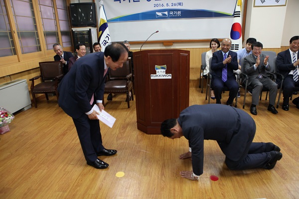 2016년 5월 26일 국기원 원장 이임식에 참석한 국기원 김태일 이사가 정만순 원장에게 준비한 선물을 전달하고 큰절하는 모습.