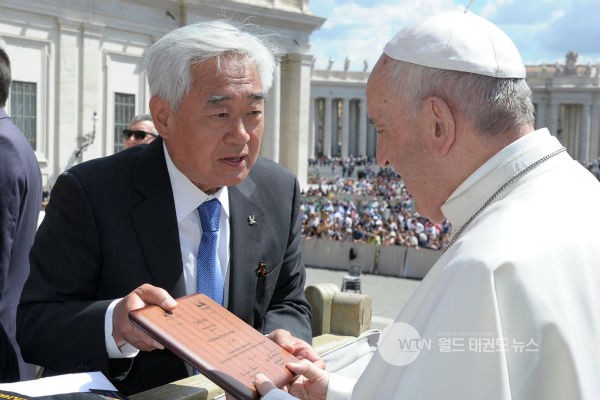 조정원 세계태권도연맹 총재가 프란치스코 교황에게 태권도 명예 10단증을 건네고있다<사진=세계태권도연맹>