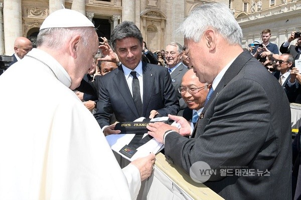▲ 조정원총재(오른쪽)가 바티칸에서 프란치스코 교황을 만나 명예 10단증과 함께 태권도 도복을 전달하고있다.